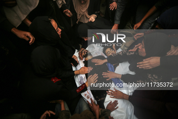 Mourners gather around the bodies of Palestinians killed in an Israeli strike amid the Israel-Hamas conflict in Deir Al-Balah, in the centra...