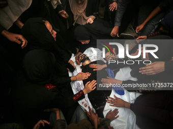 Mourners gather around the bodies of Palestinians killed in an Israeli strike amid the Israel-Hamas conflict in Deir Al-Balah, in the centra...