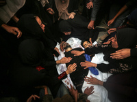 Mourners gather around the bodies of Palestinians killed in an Israeli strike amid the Israel-Hamas conflict in Deir Al-Balah, in the centra...