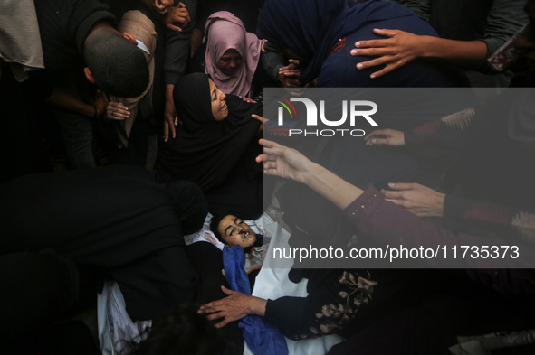 Mourners gather around the bodies of Palestinians killed in an Israeli strike amid the Israel-Hamas conflict in Deir Al-Balah, in the centra...