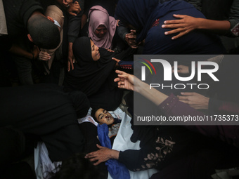 Mourners gather around the bodies of Palestinians killed in an Israeli strike amid the Israel-Hamas conflict in Deir Al-Balah, in the centra...