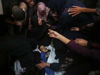 Mourners gather around the bodies of Palestinians killed in an Israeli strike amid the Israel-Hamas conflict in Deir Al-Balah, in the centra...