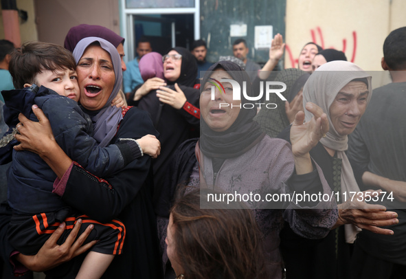 Mourners weep near the bodies of Palestinians killed in an Israeli airstrike amid the conflict between Israel and Hamas in Deir al-Balah, ce...