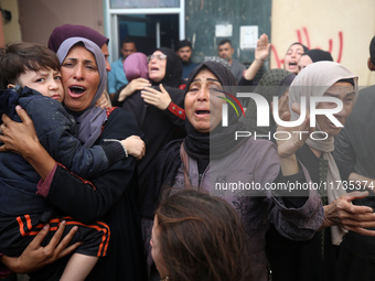 Mourners weep near the bodies of Palestinians killed in an Israeli airstrike amid the conflict between Israel and Hamas in Deir al-Balah, ce...