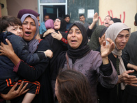 Mourners weep near the bodies of Palestinians killed in an Israeli airstrike amid the conflict between Israel and Hamas in Deir al-Balah, ce...