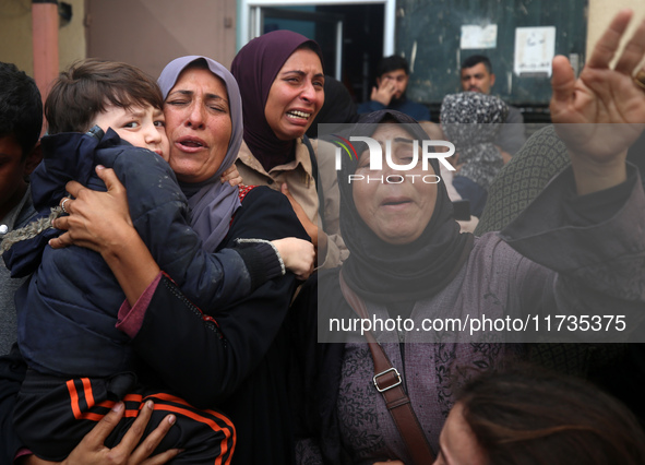 Mourners weep near the bodies of Palestinians killed in an Israeli airstrike amid the conflict between Israel and Hamas in Deir al-Balah, ce...