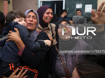 Mourners weep near the bodies of Palestinians killed in an Israeli airstrike amid the conflict between Israel and Hamas in Deir al-Balah, ce...