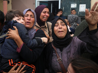 Mourners weep near the bodies of Palestinians killed in an Israeli airstrike amid the conflict between Israel and Hamas in Deir al-Balah, ce...