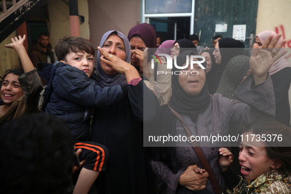 Mourners weep near the bodies of Palestinians killed in an Israeli airstrike amid the conflict between Israel and Hamas in Deir al-Balah, ce...