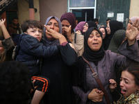 Mourners weep near the bodies of Palestinians killed in an Israeli airstrike amid the conflict between Israel and Hamas in Deir al-Balah, ce...