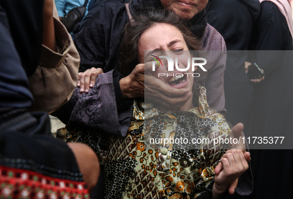 Mourners weep near the bodies of Palestinians killed in an Israeli airstrike amid the conflict between Israel and Hamas in Deir al-Balah, ce...