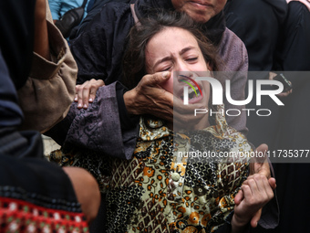 Mourners weep near the bodies of Palestinians killed in an Israeli airstrike amid the conflict between Israel and Hamas in Deir al-Balah, ce...