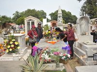 People decorate the graves of their loved ones with cempasuchil flowers at the Municipal Cemetery of San Juan del Rio. Mexicans visit the ce...