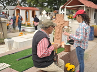 People decorate the graves of their loved ones with cempasuchil flowers at the Municipal Cemetery of San Juan del Rio. Mexicans visit the ce...