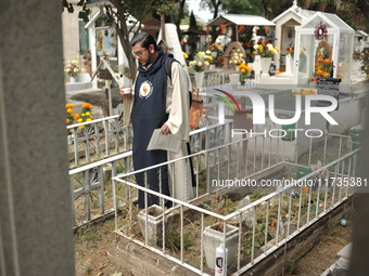 A person decorates the grave of their loved ones with cempasuchil flowers at the Municipal Cemetery of San Juan del Rio. Mexicans visit the...