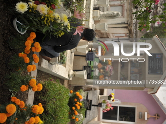 A person decorates the grave of their loved ones with cempasuchil flowers at the Municipal Cemetery of San Juan del Rio. Mexicans visit the...