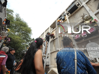 People decorate the graves of their loved ones with cempasuchil flowers at the Municipal Cemetery of San Juan del Rio. Mexicans visit the ce...