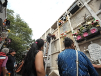 People decorate the graves of their loved ones with cempasuchil flowers at the Municipal Cemetery of San Juan del Rio. Mexicans visit the ce...