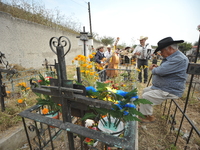 People decorate the graves of their loved ones with cempasuchil flowers at the Municipal Cemetery of San Juan del Rio. Mexicans visit the ce...