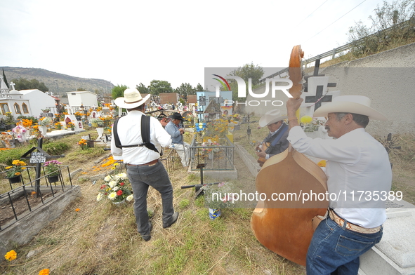 People decorate the graves of their loved ones with cempasuchil flowers at the Municipal Cemetery of San Juan del Rio. Mexicans visit the ce...