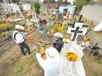 People decorate the graves of their loved ones with cempasuchil flowers at the Municipal Cemetery of San Juan del Rio. Mexicans visit the ce...