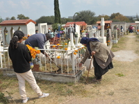 People decorate the graves of their loved ones with cempasuchil flowers at the Municipal Cemetery of San Juan del Rio. Mexicans visit the ce...