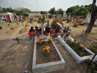 People decorate the graves of their loved ones with cempasuchil flowers at the Municipal Cemetery of San Juan del Rio. Mexicans visit the ce...