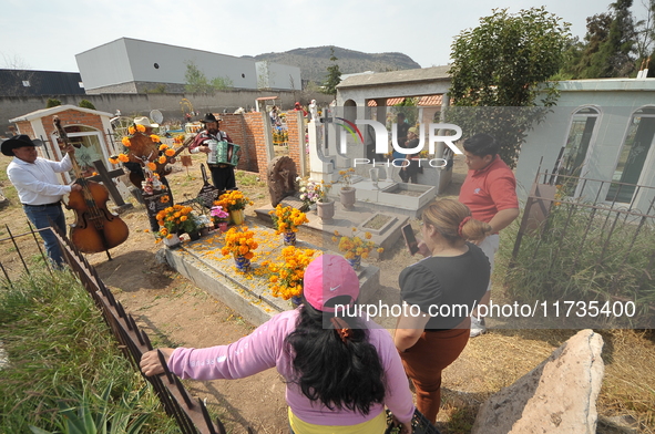 People decorate the graves of their loved ones with cempasuchil flowers at the Municipal Cemetery of San Juan del Rio. Mexicans visit the ce...