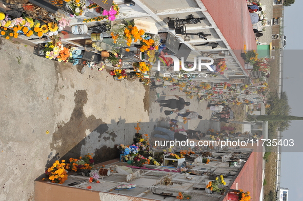 People decorate the graves of their loved ones with cempasuchil flowers at the Municipal Cemetery of San Juan del Rio. Mexicans visit the ce...