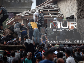 Palestinians scramble to receive sacks of flour at a United Nations Relief and Works Agency (UNRWA) aid distribution center amid the Israel-...