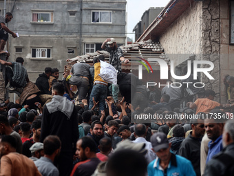 Palestinians scramble to receive sacks of flour at a United Nations Relief and Works Agency (UNRWA) aid distribution center amid the Israel-...