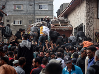 Palestinians scramble to receive sacks of flour at a United Nations Relief and Works Agency (UNRWA) aid distribution center amid the Israel-...