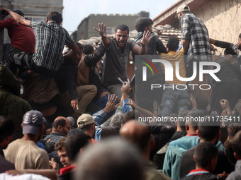 Palestinians scramble to receive sacks of flour at a United Nations Relief and Works Agency (UNRWA) aid distribution center amid the Israel-...