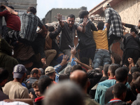 Palestinians scramble to receive sacks of flour at a United Nations Relief and Works Agency (UNRWA) aid distribution center amid the Israel-...