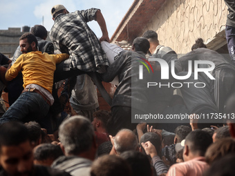 Palestinians scramble to receive sacks of flour at a United Nations Relief and Works Agency (UNRWA) aid distribution center amid the Israel-...