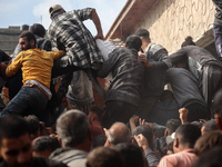 Palestinians scramble to receive sacks of flour at a United Nations Relief and Works Agency (UNRWA) aid distribution center amid the Israel-...