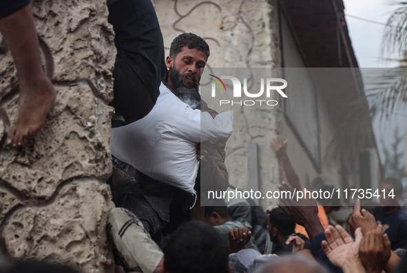 Palestinians scramble to receive sacks of flour at a United Nations Relief and Works Agency (UNRWA) aid distribution center amid the Israel-...