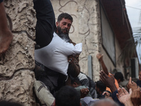 Palestinians scramble to receive sacks of flour at a United Nations Relief and Works Agency (UNRWA) aid distribution center amid the Israel-...