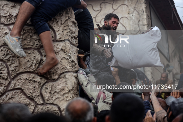 Palestinians scramble to receive sacks of flour at a United Nations Relief and Works Agency (UNRWA) aid distribution center amid the Israel-...