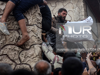 Palestinians scramble to receive sacks of flour at a United Nations Relief and Works Agency (UNRWA) aid distribution center amid the Israel-...