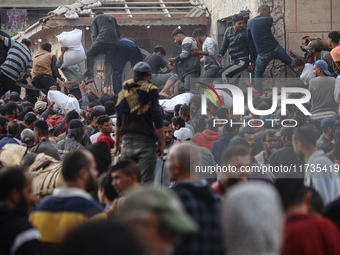 Palestinians scramble to receive sacks of flour at a United Nations Relief and Works Agency (UNRWA) aid distribution center amid the Israel-...