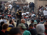 Palestinians scramble to receive sacks of flour at a United Nations Relief and Works Agency (UNRWA) aid distribution center amid the Israel-...