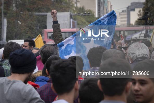 An Iranian student shouts anti-U.S. and anti-Israeli slogans while standing behind the U.S. flag, preparing to set it on fire outside the fo...