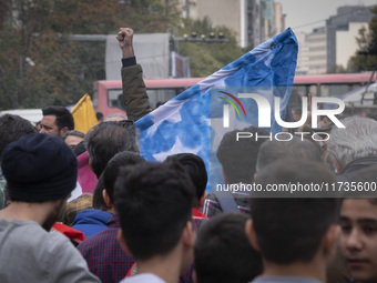 An Iranian student shouts anti-U.S. and anti-Israeli slogans while standing behind the U.S. flag, preparing to set it on fire outside the fo...