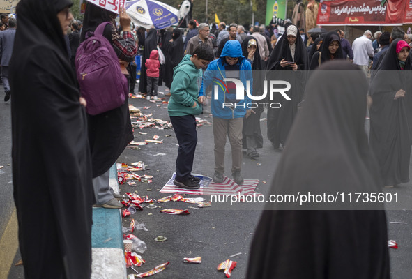 Two Iranian schoolboys stand on the U.S. flag during an anti-U.S. and anti-Israel rally marking the anniversary of the U.S. embassy occupati...