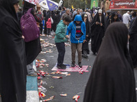 Two Iranian schoolboys stand on the U.S. flag during an anti-U.S. and anti-Israel rally marking the anniversary of the U.S. embassy occupati...