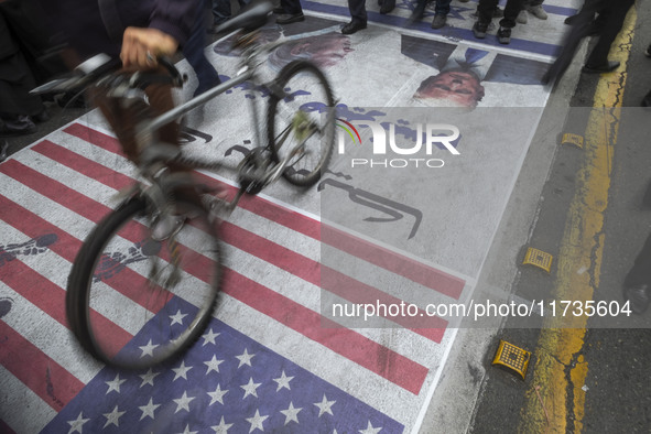 Iranian protesters walk on the U.S. flag while participating in an anti-U.S. and anti-Israel rally marking the anniversary of the U.S. embas...