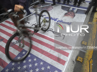 Iranian protesters walk on the U.S. flag while participating in an anti-U.S. and anti-Israel rally marking the anniversary of the U.S. embas...