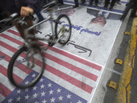 Iranian protesters walk on the U.S. flag while participating in an anti-U.S. and anti-Israel rally marking the anniversary of the U.S. embas...