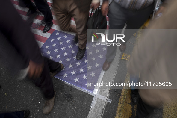 Iranian protesters walk on the U.S. flag while participating in an anti-U.S. and anti-Israel rally marking the anniversary of the U.S. embas...